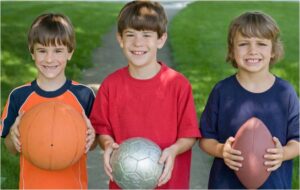 3 Kids with basketball, soccer ball, and football